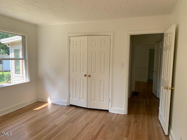 1003 Summerville Mamers Rd, Lillington, NC 27546 - unfurnished bedroom featuring light wood finished floors, a closet, and ornamental molding
