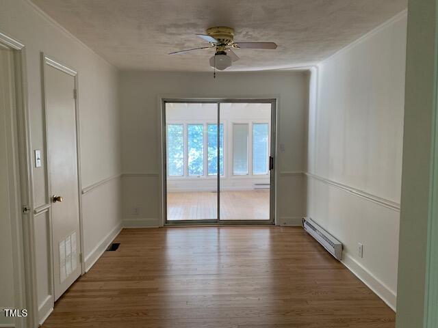 1003 Summerville Mamers Rd, Lillington, NC 27546 - spare room with baseboard heating, wood finished floors, and a ceiling fan