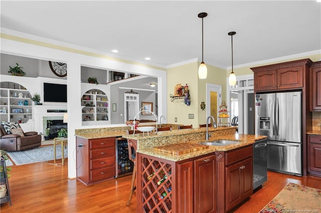 2825 Sand Trap Ln, Hope Mills, NC 28348 - kitchen with stainless steel appliances, beverage cooler, ornamental molding, wood finished floors, and a center island with sink