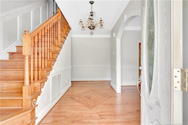 1190 Mckeller Rd, Fairmont, NC 28340 - entrance foyer with arched walkways, stairway, a chandelier, and parquet flooring
