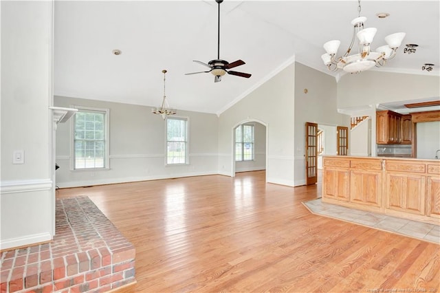1190 Mckeller Rd, Fairmont, NC 28340 - unfurnished living room with a chandelier, light wood-style floors, ceiling fan, arched walkways, and ornamental molding