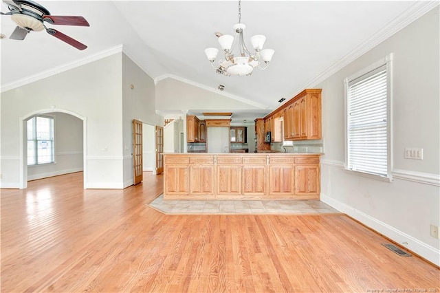 1190 Mckeller Rd, Fairmont, NC 28340 - kitchen with arched walkways, a chandelier, a peninsula, ceiling fan, and light wood-type flooring
