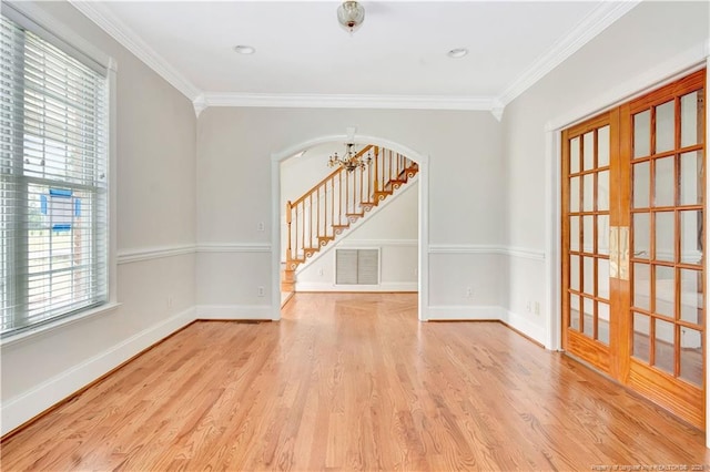1190 Mckeller Rd, Fairmont, NC 28340 - spare room featuring arched walkways, ornamental molding, wood finished floors, stairs, and french doors