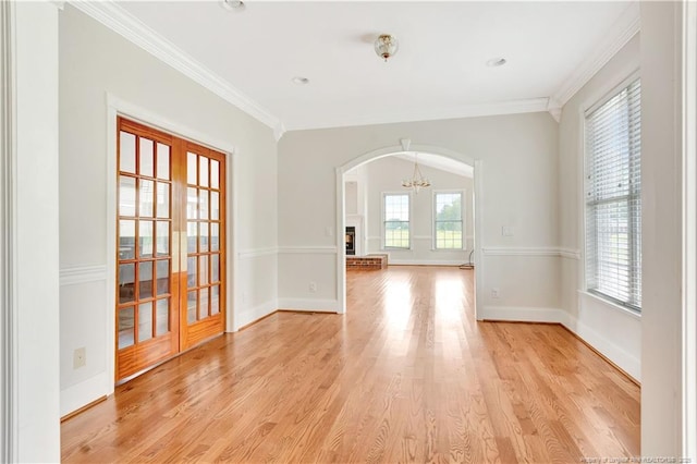1190 Mckeller Rd, Fairmont, NC 28340 - empty room with arched walkways, a chandelier, light wood-type flooring, ornamental molding, and french doors