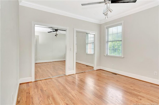 1190 Mckeller Rd, Fairmont, NC 28340 - unfurnished bedroom featuring multiple closets, ornamental molding, wood finished floors, and a ceiling fan