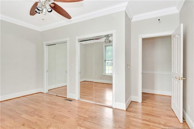 1190 Mckeller Rd, Fairmont, NC 28340 - unfurnished bedroom with ornamental molding, two closets, light wood-style flooring, and ceiling fan