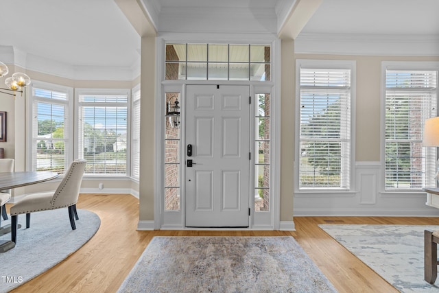 12510 Megan Hill Ct, Raleigh, NC 27614 - entrance foyer with ornamental molding, wood finished floors, and a chandelier