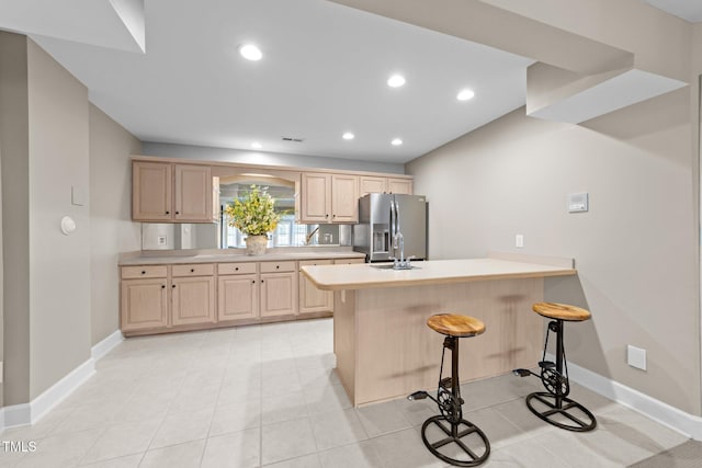 12510 Megan Hill Ct, Raleigh, NC 27614 - kitchen featuring stainless steel refrigerator with ice dispenser, light brown cabinetry, a peninsula, a breakfast bar area, and recessed lighting