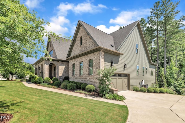 2203 Meadowcreek Dr, Durham, NC 27705 - view of property exterior featuring an attached garage, brick siding, concrete driveway, a lawn, and roof with shingles