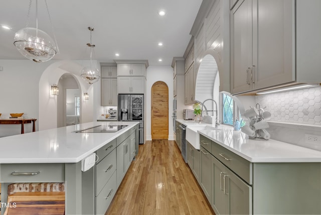 2203 Meadowcreek Dr, Durham, NC 27705 - kitchen with appliances with stainless steel finishes, arched walkways, a spacious island, recessed lighting, and gray cabinets