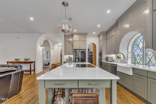 2203 Meadowcreek Dr, Durham, NC 27705 - kitchen with arched walkways, stainless steel appliances, green cabinets, a chandelier, and light countertops
