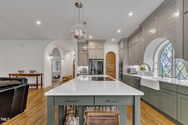 2203 Meadowcreek Dr, Durham, NC 27705 - kitchen featuring green cabinetry, stainless steel appliances, arched walkways, a kitchen bar, and light countertops