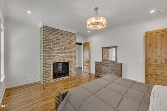 2203 Meadowcreek Dr, Durham, NC 27705 - bedroom with crown molding, a brick fireplace, wood finished floors, a chandelier, and recessed lighting