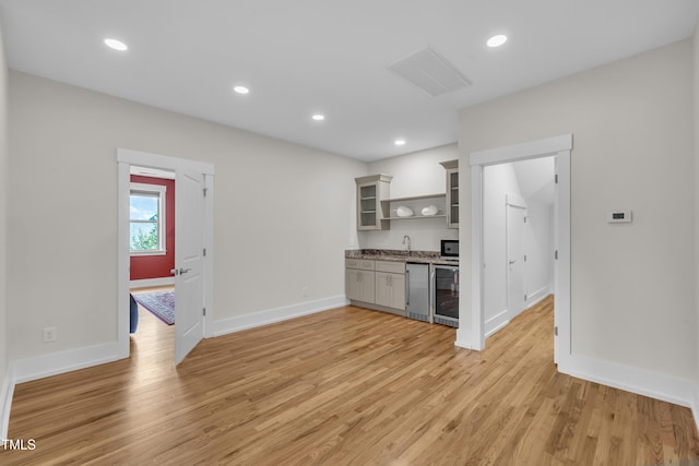 2203 Meadowcreek Dr, Durham, NC 27705 - kitchen featuring open shelves, light wood-type flooring, wine cooler, recessed lighting, and glass insert cabinets