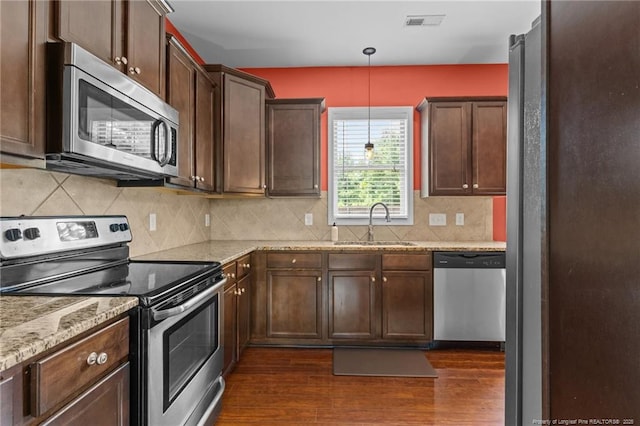 6204 Yorkie Ct, Stedman, NC 28391 - kitchen with appliances with stainless steel finishes, dark wood finished floors, light stone countertops, backsplash, and decorative light fixtures