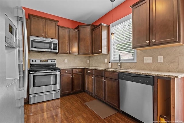 6204 Yorkie Ct, Stedman, NC 28391 - kitchen featuring appliances with stainless steel finishes, dark wood-style floors, light stone countertops, and decorative backsplash