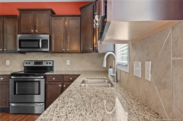 6204 Yorkie Ct, Stedman, NC 28391 - kitchen featuring appliances with stainless steel finishes, light stone countertops, dark brown cabinets, dark wood-style flooring, and tasteful backsplash