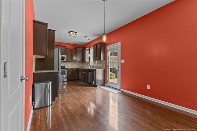 6204 Yorkie Ct, Stedman, NC 28391 - kitchen with stainless steel appliances, dark wood-type flooring, decorative backsplash, dark brown cabinets, and decorative light fixtures