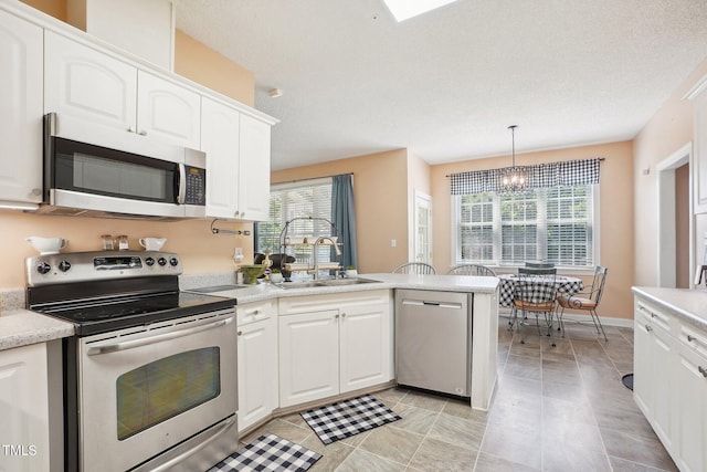 683 Castleberry Rd, Clayton, NC 27527 - kitchen with stainless steel appliances, a peninsula, light countertops, and white cabinets