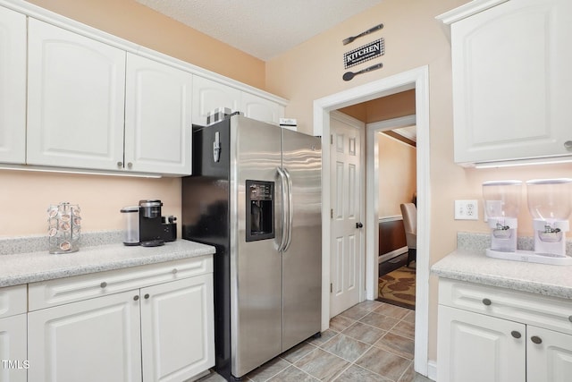 683 Castleberry Rd, Clayton, NC 27527 - kitchen featuring stainless steel fridge, white cabinetry, light stone counters, and a textured ceiling