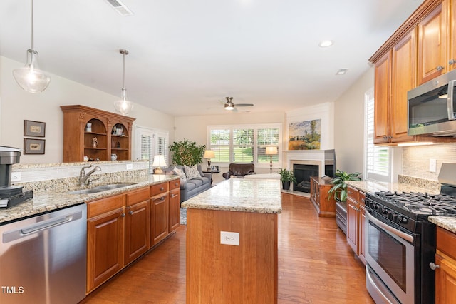 5030 Homeplace Dr, Apex, NC 27539 - kitchen with stainless steel appliances, ceiling fan, decorative backsplash, a kitchen island, and a fireplace
