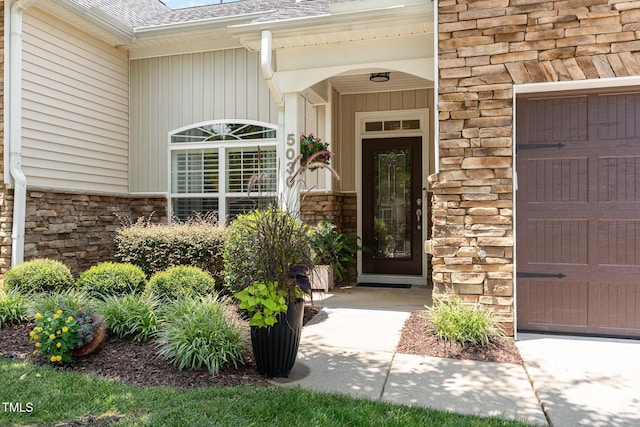 5030 Homeplace Dr, Apex, NC 27539 - doorway to property with stone siding, roof with shingles, and a garage