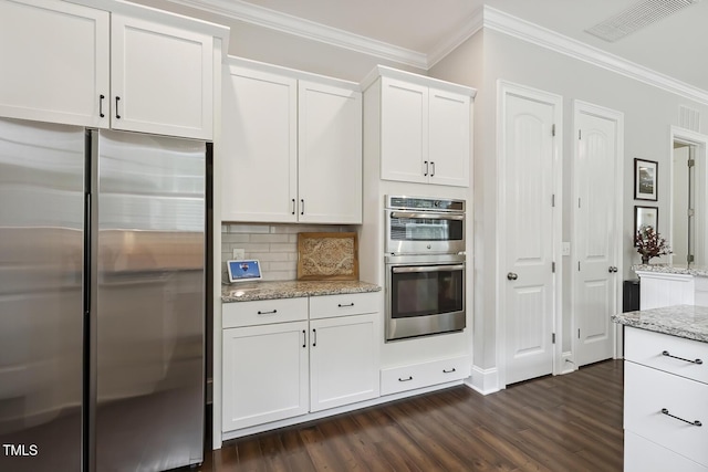 669 Fallon Grove Way, Raleigh, NC 27608 - kitchen featuring appliances with stainless steel finishes, crown molding, dark wood-style floors, white cabinets, and decorative backsplash