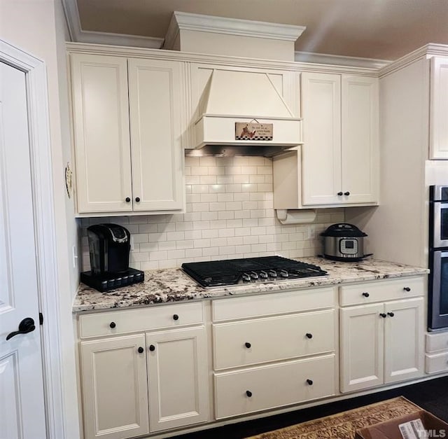 1869 Blue Jay Pt, Apex, NC 27502 - kitchen featuring stainless steel gas cooktop, custom exhaust hood, white cabinets, and crown molding