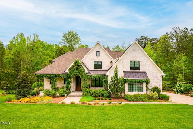 5040 Shakori Trl, Durham, NC 27707 - view of front of home with a front lawn, a standing seam roof, covered porch, and roof with shingles