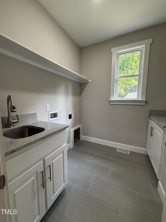 1119 Sagamore Dr, Louisburg, NC 27549 - laundry room featuring washer hookup, dark tile patterned floors, cabinet space, and electric dryer hookup