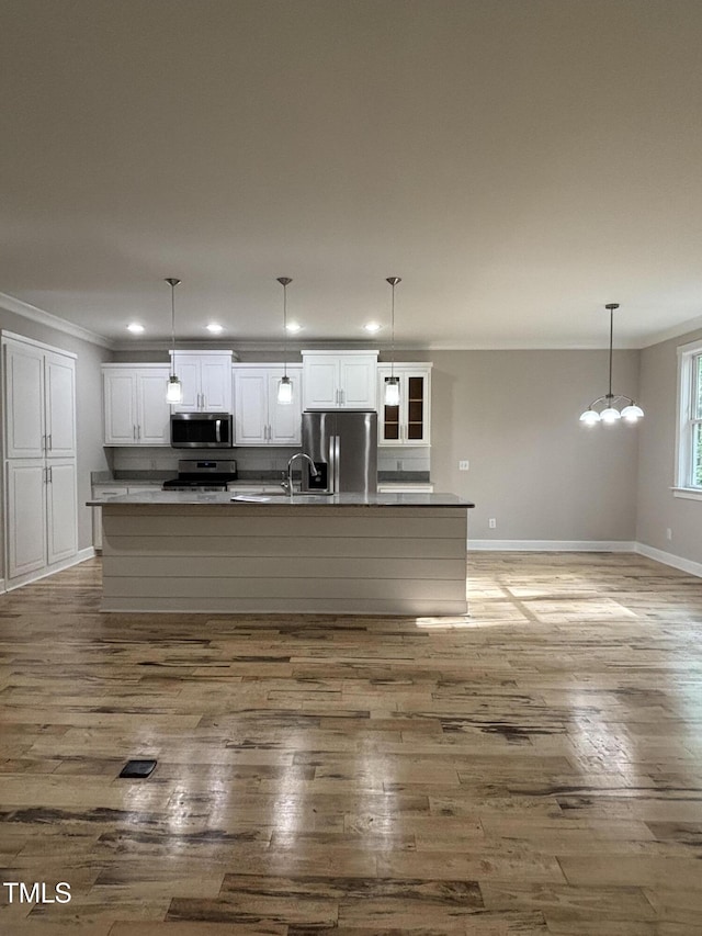 1119 Sagamore Dr, Louisburg, NC 27549 - kitchen featuring stainless steel appliances, ornamental molding, white cabinetry, wood finished floors, and a large island
