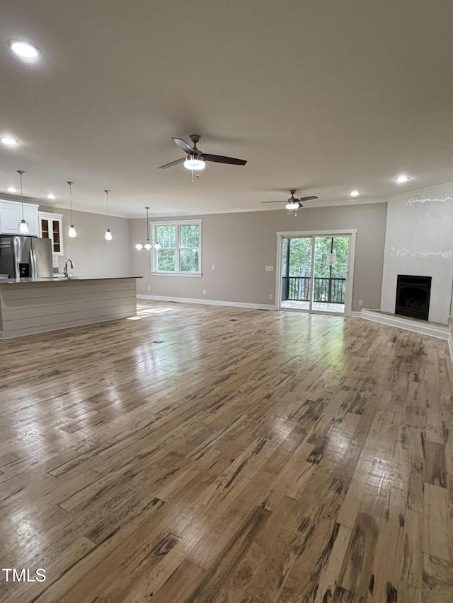 1119 Sagamore Dr, Louisburg, NC 27549 - unfurnished living room with wood finished floors, plenty of natural light, a fireplace, and recessed lighting