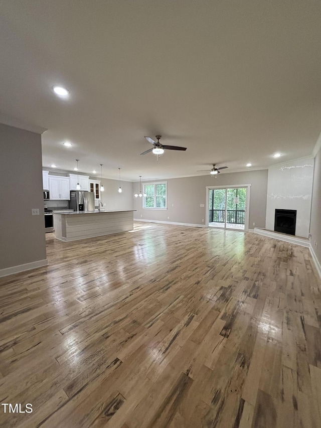 1119 Sagamore Dr, Louisburg, NC 27549 - unfurnished living room with wood finished floors, recessed lighting, a large fireplace, and ceiling fan