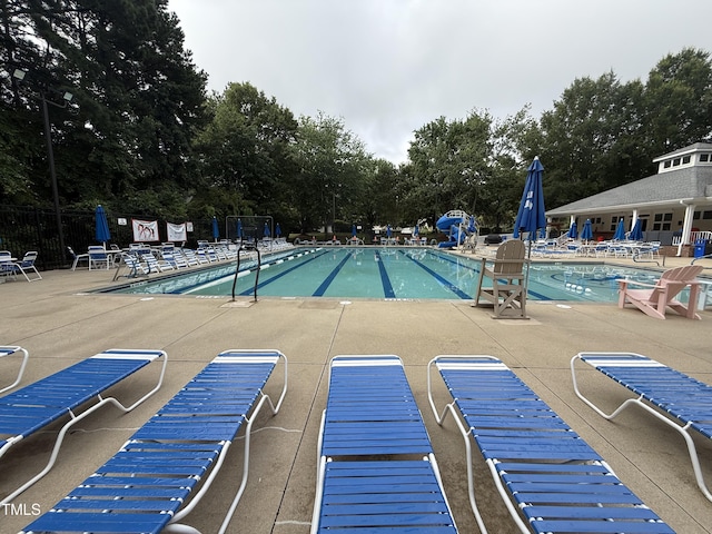 241 Commons Dr, Holly Springs, NC 27540 - community pool with a patio area and view of wooded area