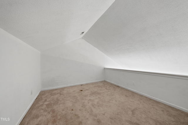 241 Commons Dr, Holly Springs, NC 27540 - additional living space featuring lofted ceiling, a textured ceiling, and carpet floors