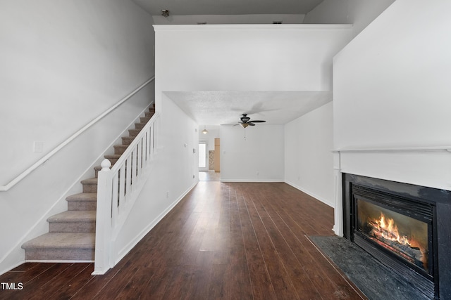 241 Commons Dr, Holly Springs, NC 27540 - unfurnished living room with a fireplace with flush hearth, stairs, hardwood / wood-style floors, and a ceiling fan