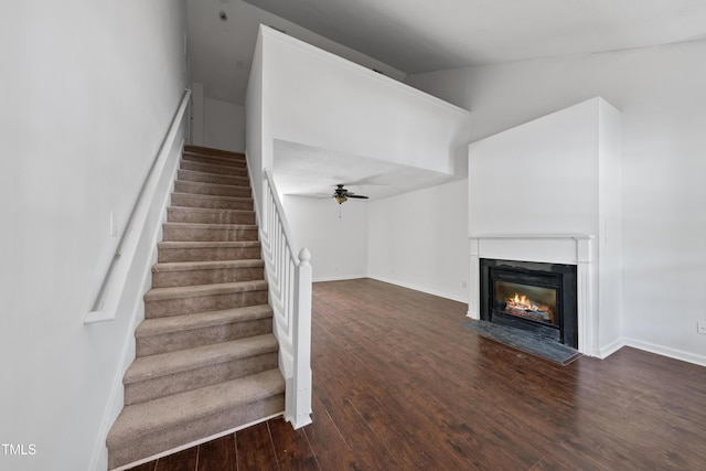 241 Commons Dr, Holly Springs, NC 27540 - staircase with wood finished floors, a glass covered fireplace, a ceiling fan, and lofted ceiling