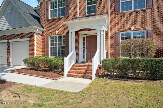 2021 Patapsco Dr, Apex, NC 27523 - view of exterior entry featuring brick siding, driveway, and a shingled roof