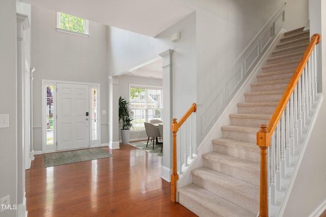 2021 Patapsco Dr, Apex, NC 27523 - entryway featuring plenty of natural light, stairs, wood finished floors, decorative columns, and a towering ceiling