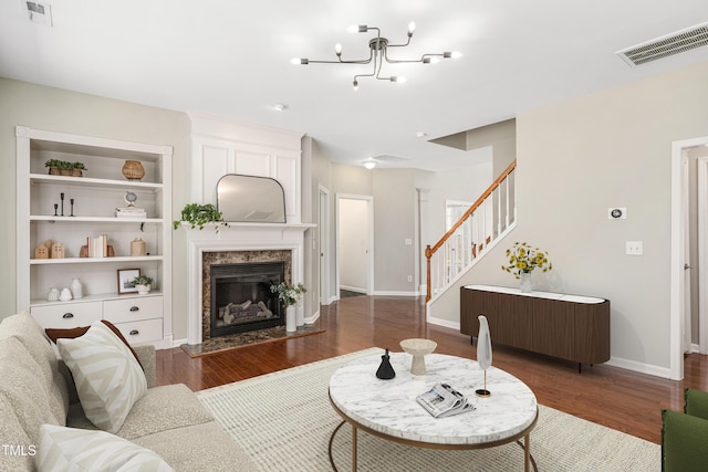 2021 Patapsco Dr, Apex, NC 27523 - living room with wood finished floors, stairs, a fireplace, and a chandelier