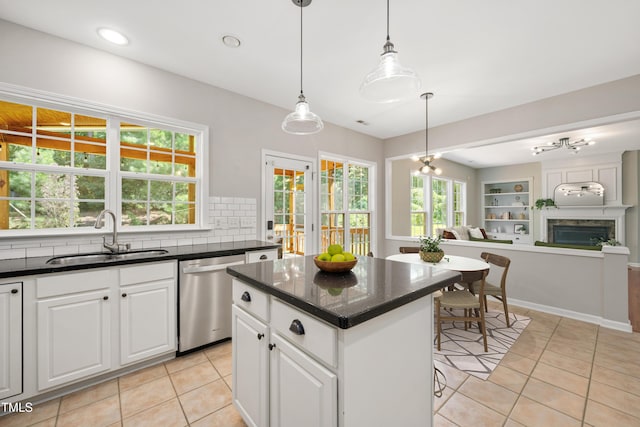 2021 Patapsco Dr, Apex, NC 27523 - kitchen with stainless steel dishwasher, light tile patterned flooring, open floor plan, a kitchen island, and white cabinetry