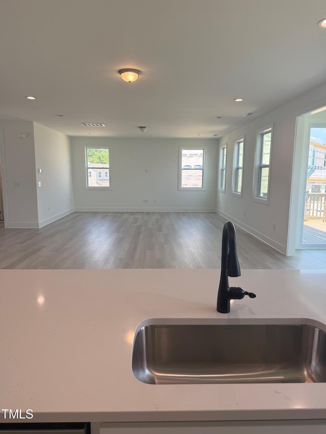 3731 Lebrun Path Unit 150Gunnison Cl, Fuquay Varina, NC 27526 - kitchen with open floor plan, light wood finished floors, recessed lighting, and light stone counters