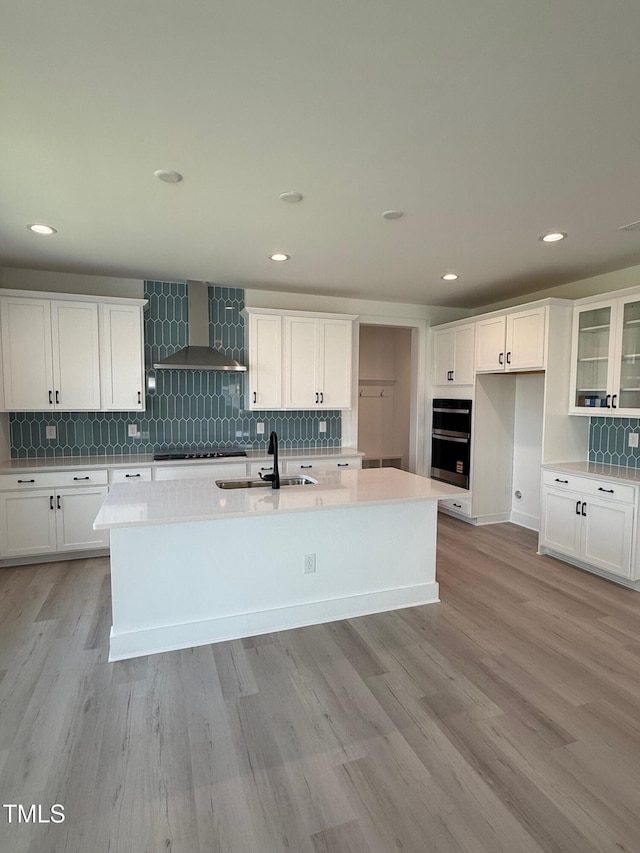 3731 Lebrun Path Unit 150Gunnison Cl, Fuquay Varina, NC 27526 - kitchen featuring wall chimney range hood, tasteful backsplash, an island with sink, white cabinets, and recessed lighting