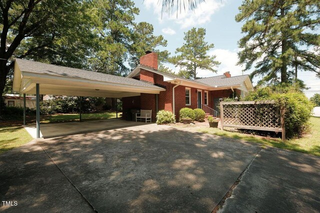 1801 Bethlehem Rd, Rocky Mount, NC 27803 - view of front facade featuring concrete driveway, a chimney, and brick siding