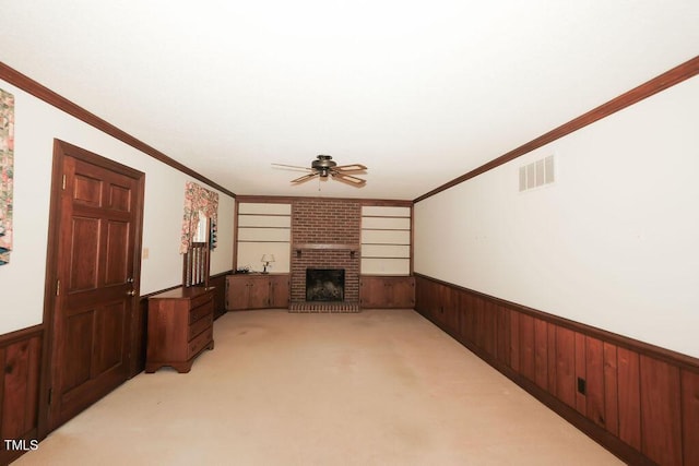 1801 Bethlehem Rd, Rocky Mount, NC 27803 - unfurnished living room with wainscoting, ceiling fan, wooden walls, light colored carpet, and a brick fireplace