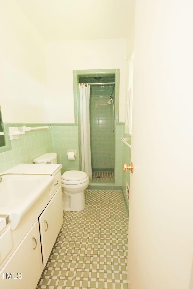 1801 Bethlehem Rd, Rocky Mount, NC 27803 - bathroom featuring vanity, tile patterned floors, tiled shower, tile walls, and a wainscoted wall