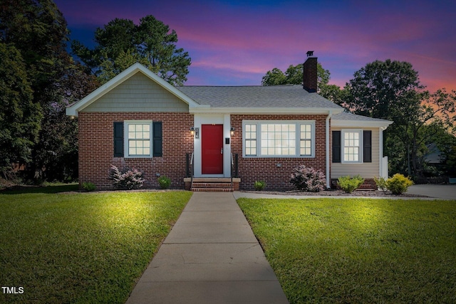 216 Whitfield St, Enfield, NC 27823 - view of front facade featuring a lawn, a chimney, brick siding, and entry steps