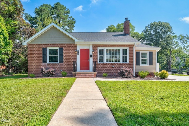 216 Whitfield St, Enfield, NC 27823 - bungalow featuring a chimney, a front lawn, brick siding, and roof with shingles