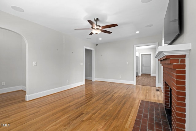 216 Whitfield St, Enfield, NC 27823 - unfurnished living room with ceiling fan, a brick fireplace, light wood-type flooring, arched walkways, and recessed lighting