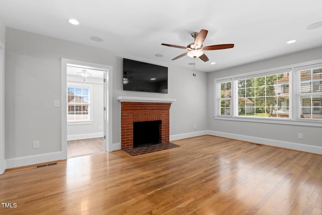 216 Whitfield St, Enfield, NC 27823 - unfurnished living room with light wood-style flooring, a ceiling fan, plenty of natural light, a brick fireplace, and recessed lighting